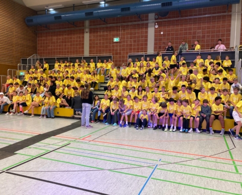 Alle Kinder der Schlossnight sitzen in ihren gelben Tshirts auf der Tribüne