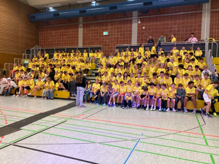 Schlossnight_10 Alle Kinder der Schlossnight sitzen in ihren gelben Tshirts auf der Tribüne