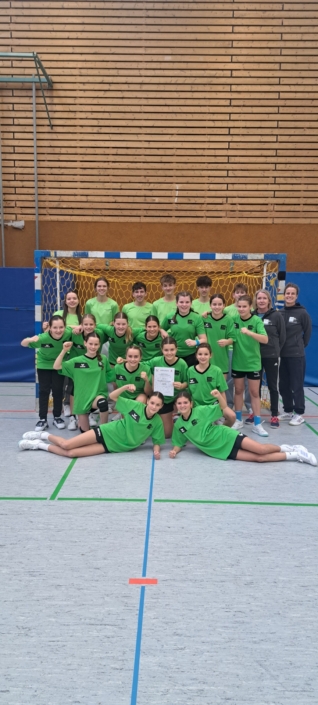 Die Spielerinnen und Lehrerinnen vor dem Tor in grünen Trikots