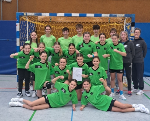 Die Spielerinnen und Lehrerinnen vor dem Tor in grünen Trikots